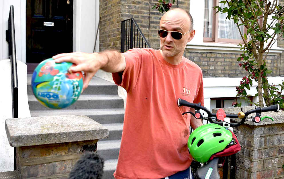 Number 10 Downing Street special advisor Dominic Cummings gestures to members of the media to observe social distancing guidelines while he holds a child's bicycle and a ball outside his home in London on May 23, 2020 after allegations he broke coronavirus lockdown rules by travelling across the country in March. - The British government on May 23 rejected calls to sack top adviser Dominic Cummings over allegations he broke coronavirus lockdown rules by travelling across the country while displaying symptoms of the disease. Cummings left his London home shortly after he was diagnosed with the virus on March 30, and was later seen with his young son close to his parents' home in Durham, more than 250 miles (400 kilometres) away. (Photo by DANIEL LEAL-OLIVAS / AFP) (Photo by DANIEL LEAL-OLIVAS/AFP via Getty Images)