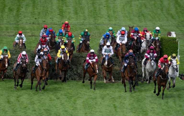 Grand National horses jumping a fence at Aintree