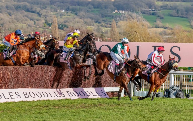 Horses jump a fence in the Cheltenham Gold Cup