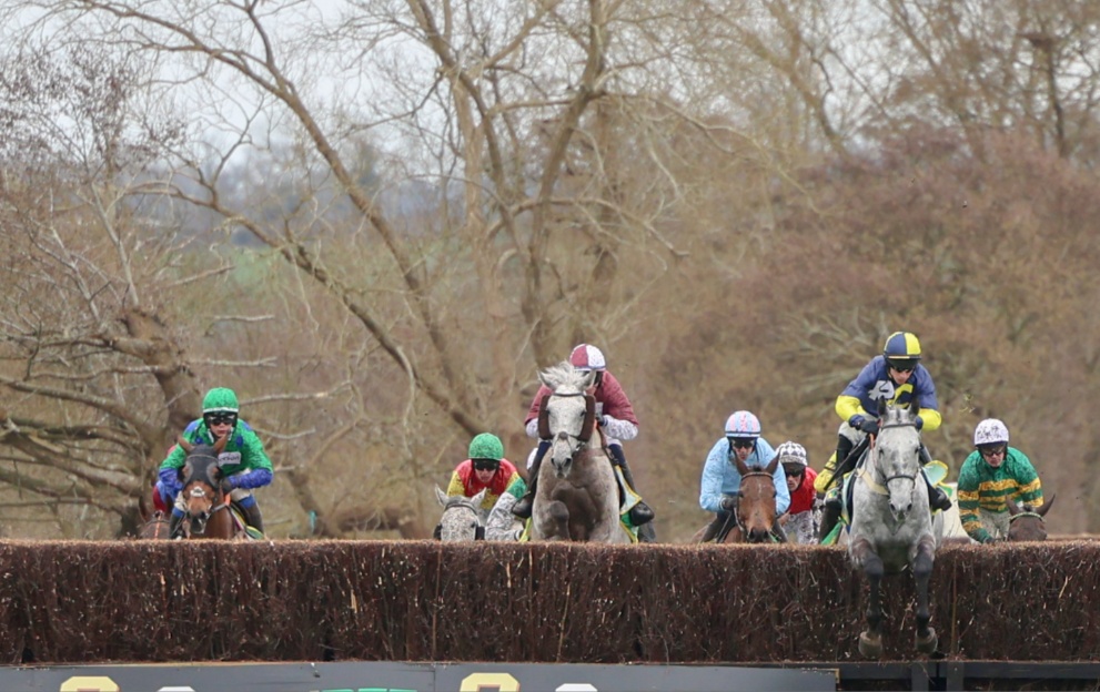 Horses jumping a fence in the Midlands Grand National at Uttoxeter