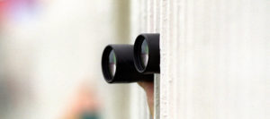 A pair of binoculars sticking out from behind railings