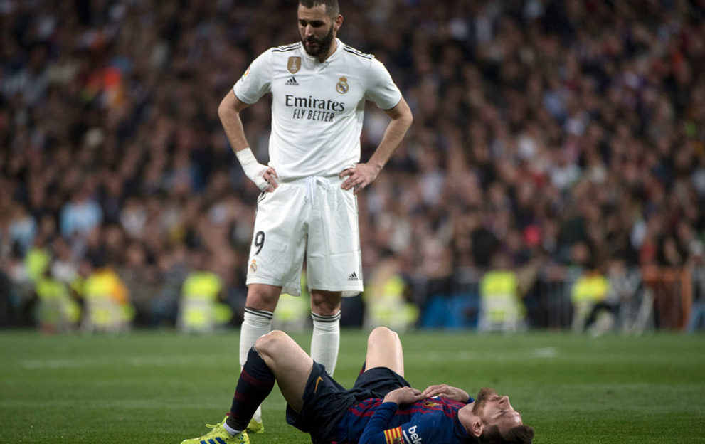 Barcelona's Argentinian forward Lionel Messi lies on the field beside Real Madrid's French forward Karim Benzema (TOP) during the Spanish league football match between Real Madrid CF and FC Barcelona at the Santiago Bernabeu stadium in Madrid on March 2, 2019. (Photo by CURTO DE LA TORRE / AFP) (Photo credit should read CURTO DE LA TORRE/AFP via Getty Images)