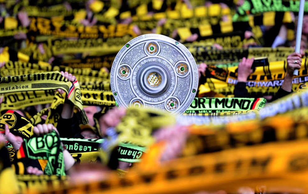 Supporters of Borussia Dortmund show a mock trophy prior to the German first division Bundesliga football match Borussia Dortmund vs Borussia Moenchengladbach in the German city of Dortmund on April 21, 2012. AFP PHOTO / PATRIK STOLLARZ RESTRICTIONS / EMBARGO - DFL LIMITS THE USE OF IMAGES ON THE INTERNET TO 15 PICTURES (NO VIDEO-LIKE SEQUENCES) DURING THE MATCH AND PROHIBITS MOBILE (MMS) USE DURING AND FOR FURTHER TWO HOURS AFTER THE MATCH. FOR MORE INFORMATION CONTACT DFL. (Photo by Patrik STOLLARZ / AFP) (Photo by PATRIK STOLLARZ/AFP via Getty Images)