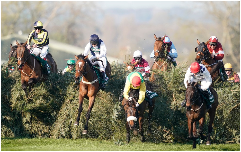 Horses jump a fence at the Grand National