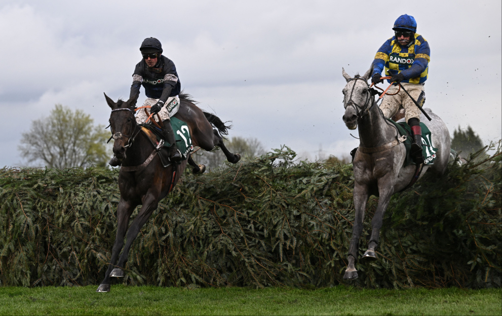 Horses jump a fence at Aintree