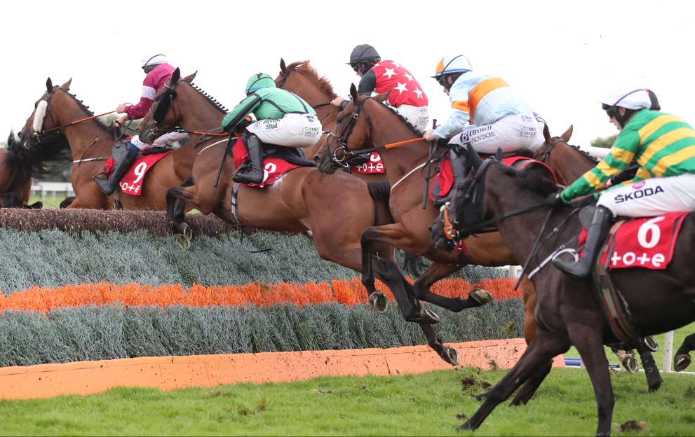 Horses jump a fence in the Galway Plate